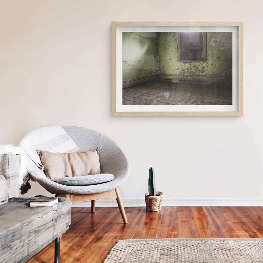 Bare Guest Room at Terminus Hotel, light seeps in through a boarded window, casting a dull glow across the floorboards.