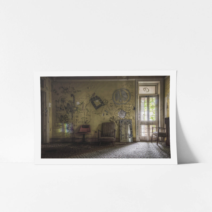 Common Room at Terminus Hotel, a faded yellow wall covered floor to ceiling in graffiti and marker scrawl.
