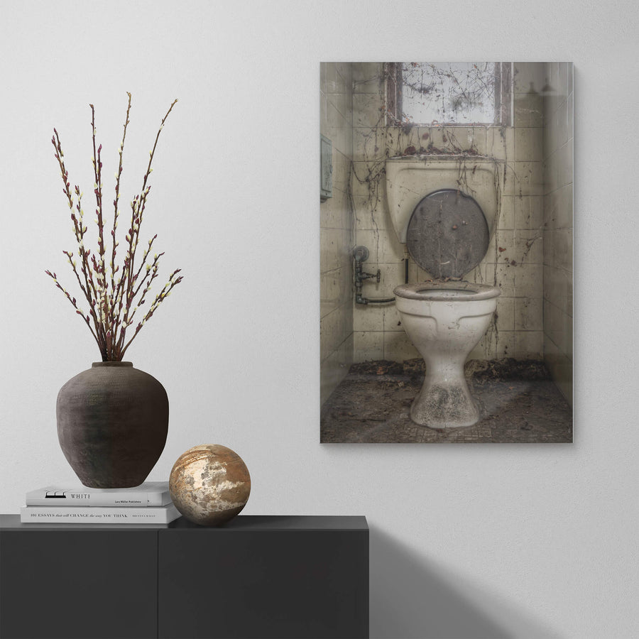 Toilet at Terminus Hotel, a white ceramic pedestal toilet sits centred in a narrow tiled cubicle.