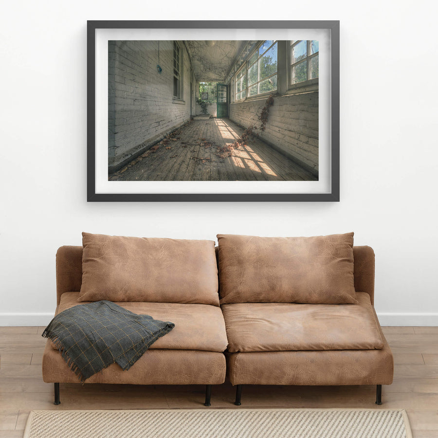 Balcony at The Asylum, a narrow enclosed verandah runs between white-painted brick walls.