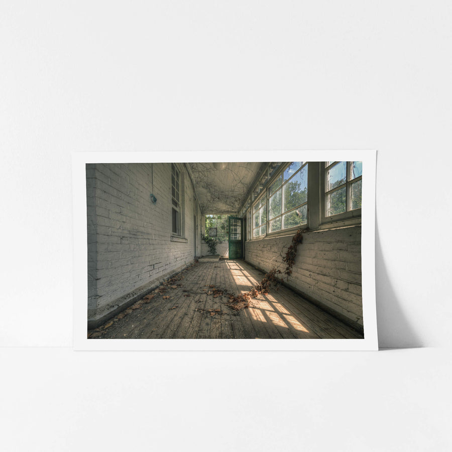 Balcony at The Asylum, a narrow enclosed verandah runs between white-painted brick walls.