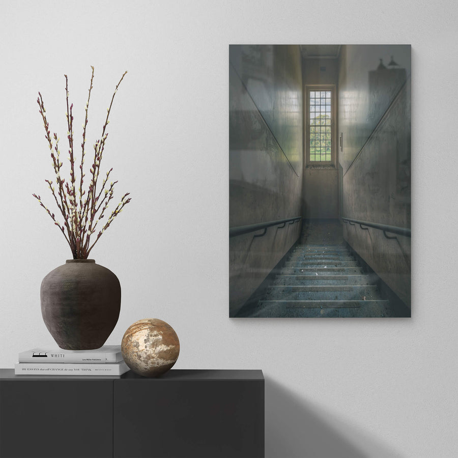 Glimmer at The Asylum, a concrete stairwell descends between narrow walls.