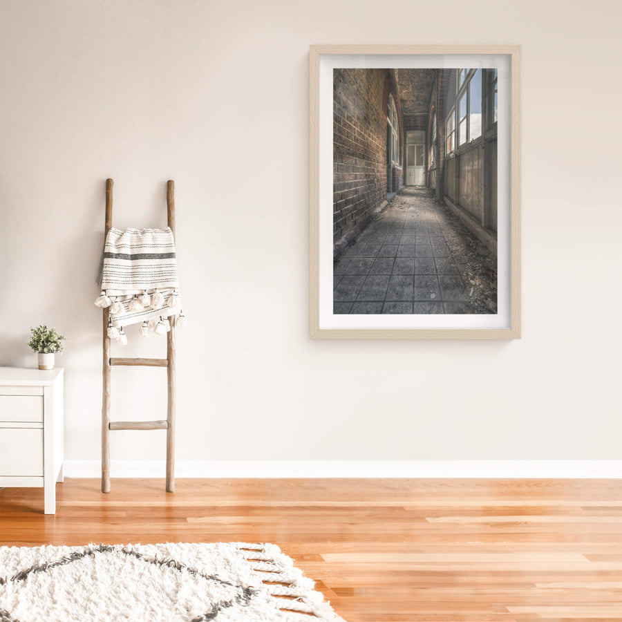 In Between at The Asylum, a narrow corridor runs between a brick wall and a timber-panelled enclosure.
