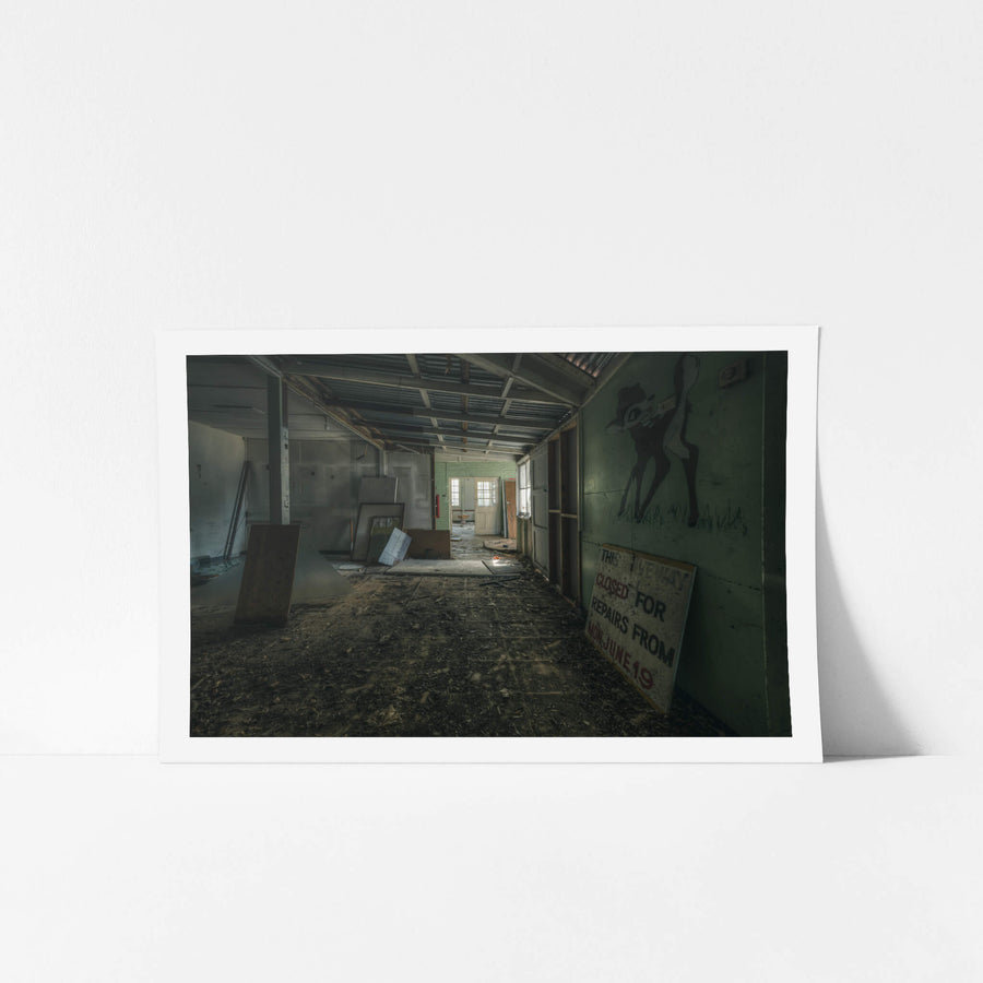 Mixed Signals at The Asylum, a long corridor stretches toward a green-tiled doorway at the far end.