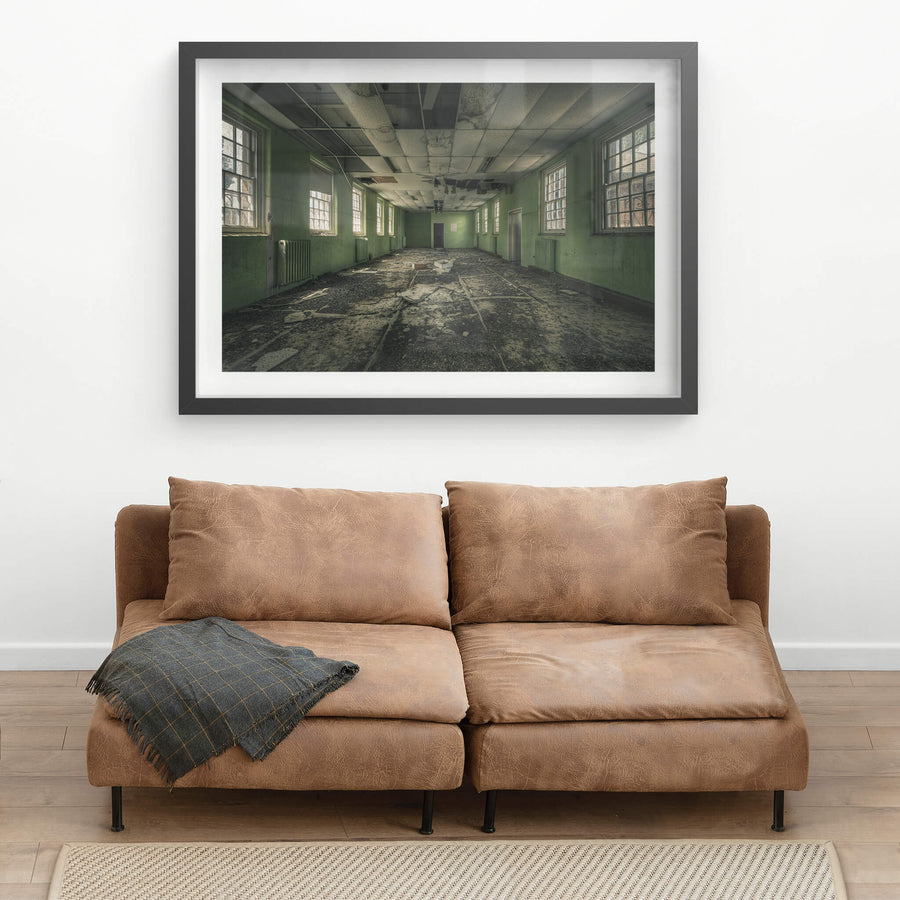 Narrow Green Room at The Asylum, a long rectangular room stretches toward a single door at the far end.