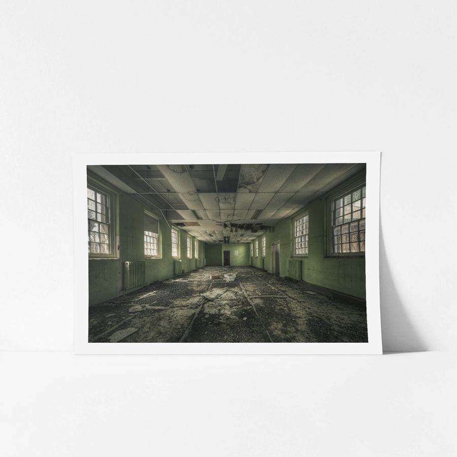 Narrow Green Room at The Asylum, a long rectangular room stretches toward a single door at the far end.