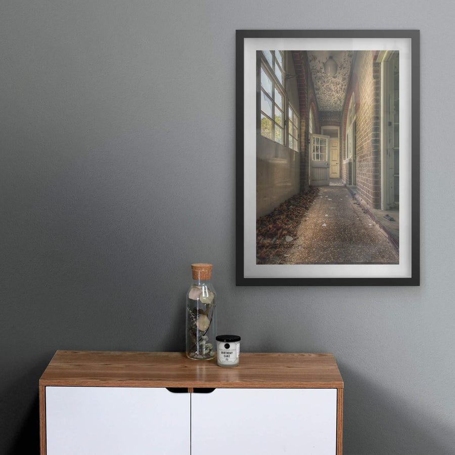 Pebblecrete Pavers at The Asylum, a narrow corridor runs between red brick columns and a rendered half-wall.