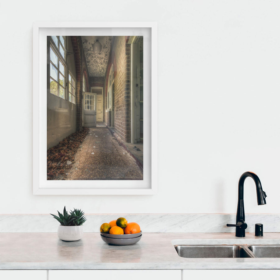 Pebblecrete Pavers at The Asylum, a narrow corridor runs between red brick columns and a rendered half-wall.