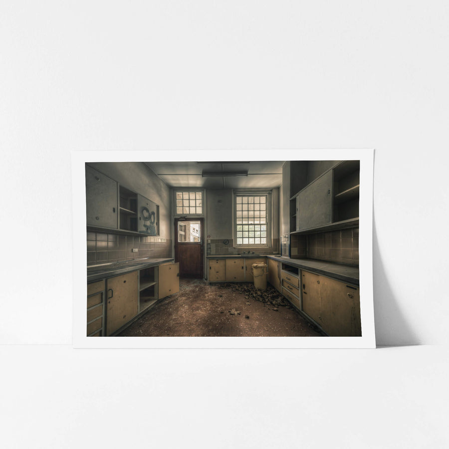 Prep Kitchen at The Asylum, a U-shaped bench runs the length of the room, laminate doors hanging open on empty cupboards.