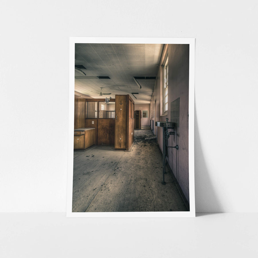 Slipping Away at The Asylum, a stainless steel basin hangs from exposed plumbing on the corridor wall.