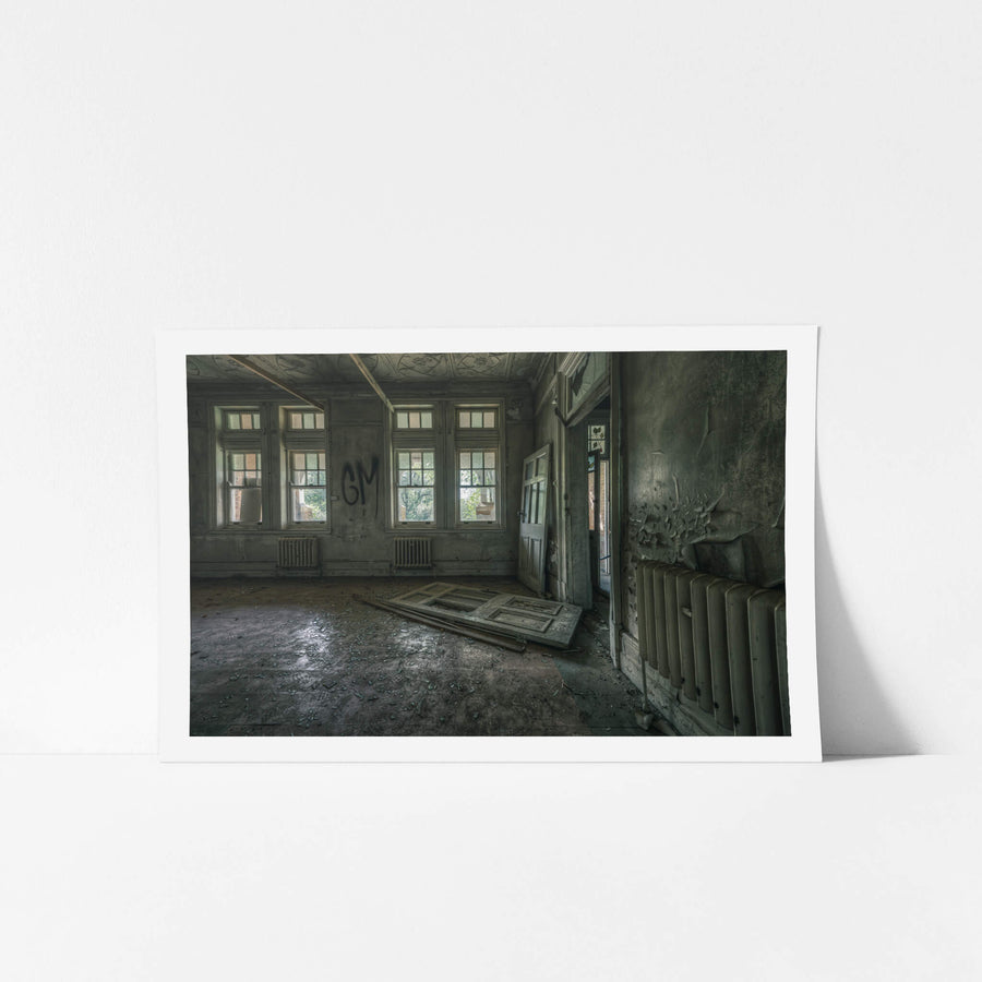 The Back Residence at The Asylum, a panelled door lies flat on the floor, torn from its hinges.