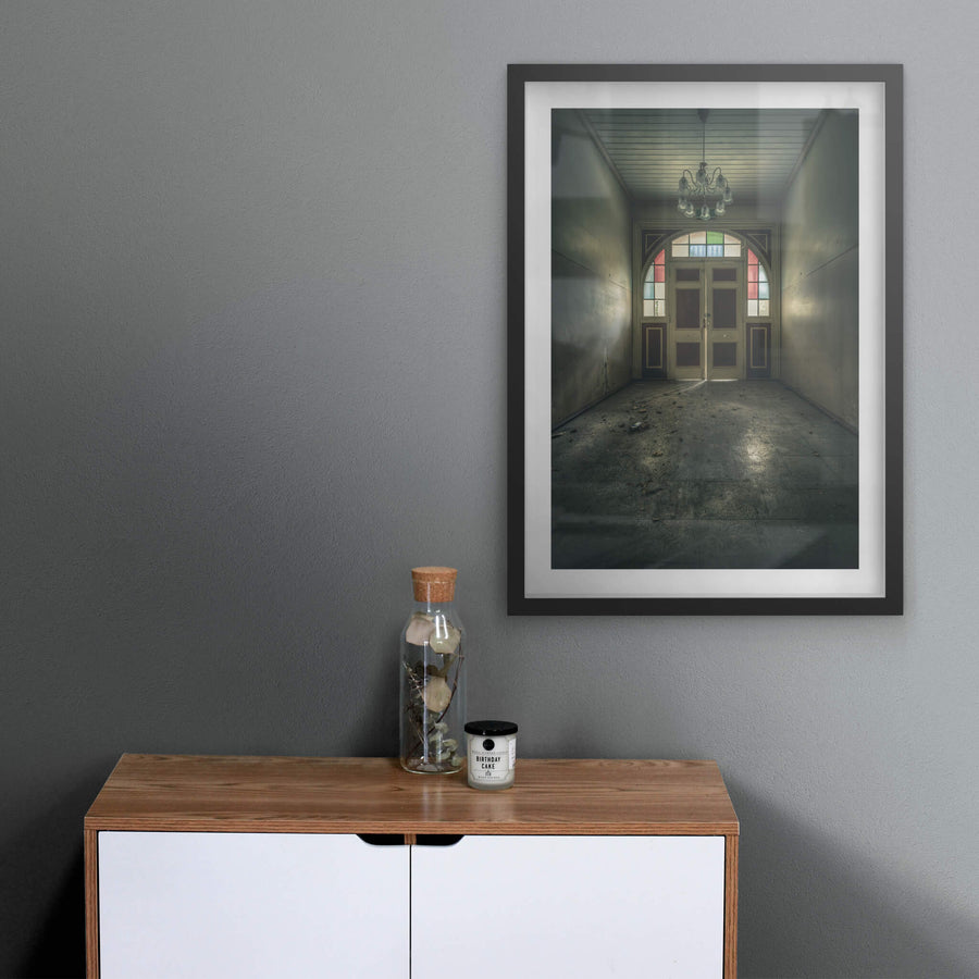 The Grand Entrance at The Asylum, a narrow entrance hall opens toward double timber doors set within an arched frame.