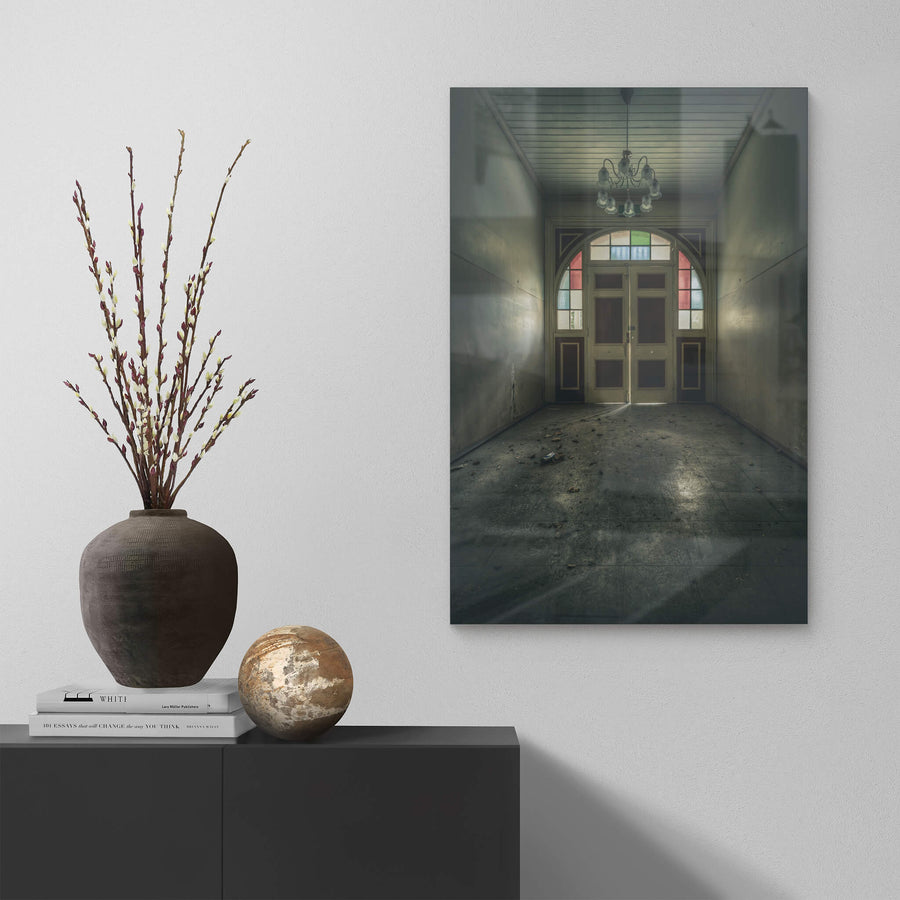 The Grand Entrance at The Asylum, a narrow entrance hall opens toward double timber doors set within an arched frame.