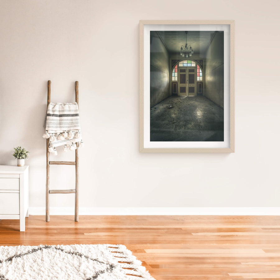 The Grand Entrance at The Asylum, a narrow entrance hall opens toward double timber doors set within an arched frame.