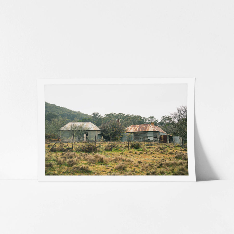 Across the Paddock at The Post Office, two weatherboard buildings sit low in a tussock paddock.