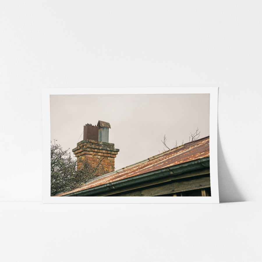 Chimneys at The Post Office, a brick chimney rises from the roofline, its mortar cracked and lichen-spotted.