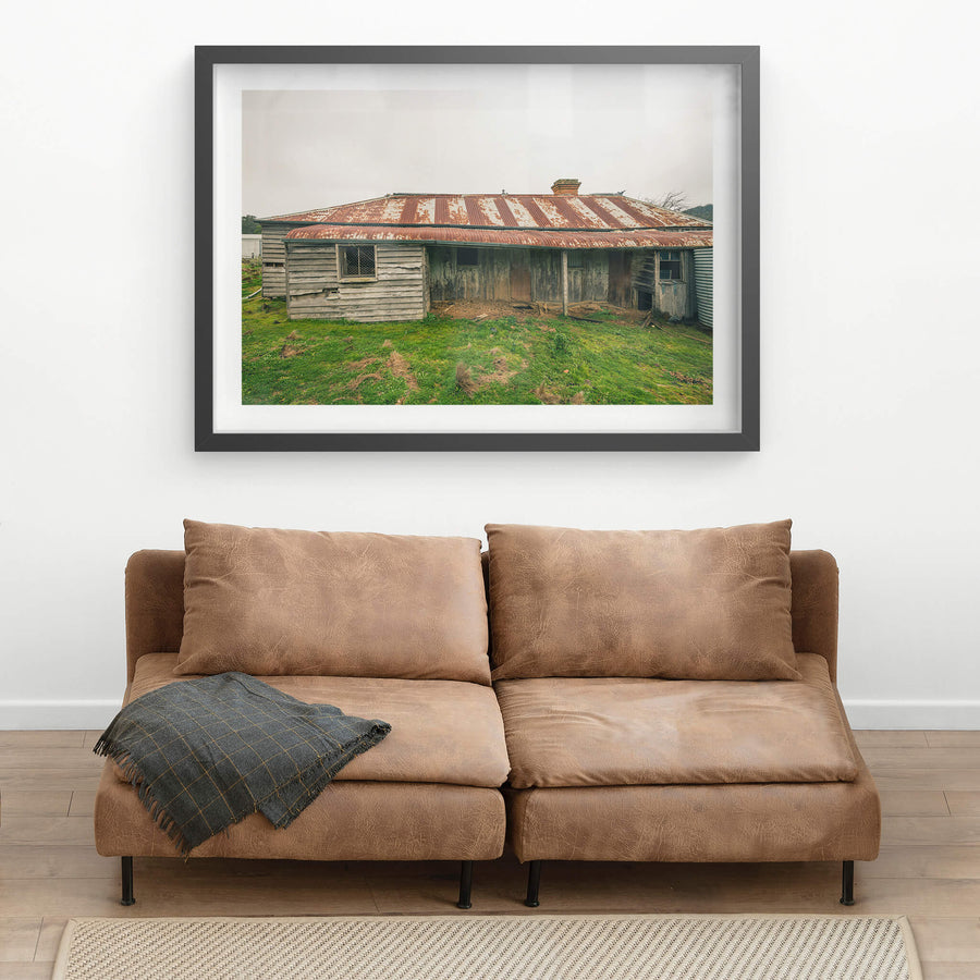 Front Yard at The Post Office, a low-slung timber homestead sits under a corrugated iron roof mottled with rust.