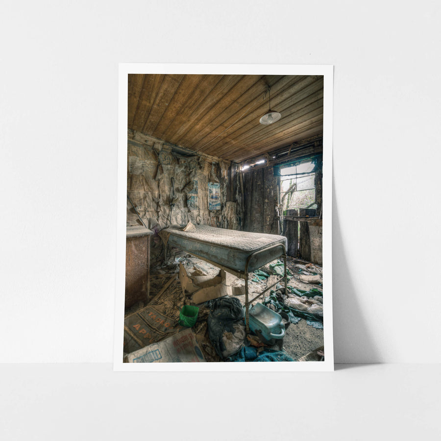 Smaller Bedroom at The Post Office, a single bed frame sits raised on metal legs, its stained mattress still intact.
