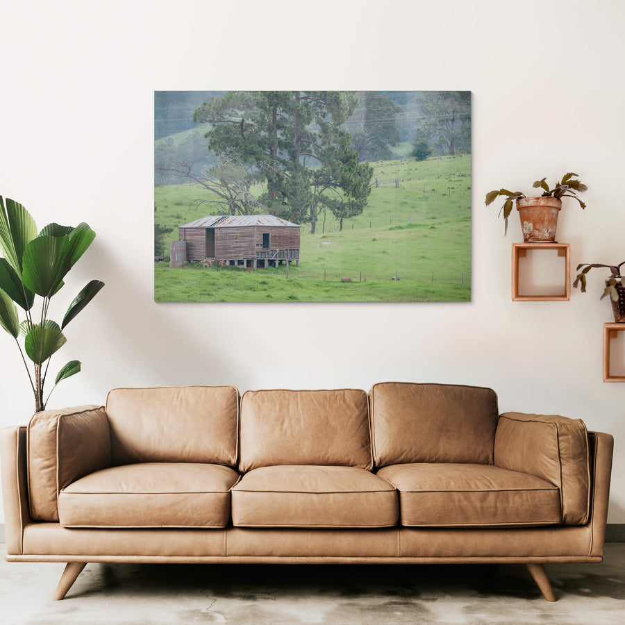 Bemboka Woolshed at The Woolshed, a weatherboard woolshed sits on low timber stumps against a slope of green pasture.