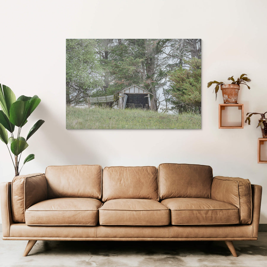 Hilltop Shed at The Woolshed, a small timber shed sits low on a grassed hilltop, its gable face open to the paddock.