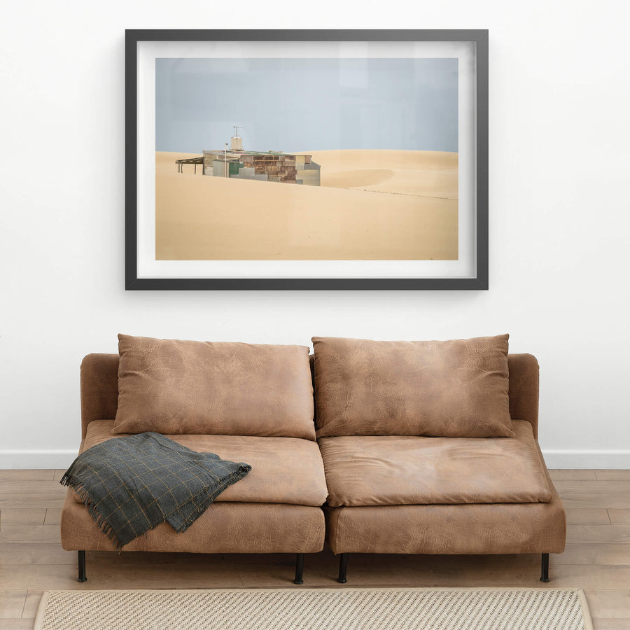 Buried at Tin City, a Tin City shack, recessed in rolling dunes of sand.
