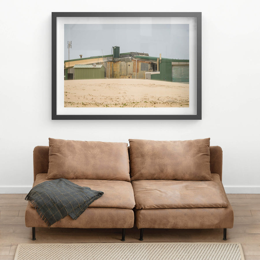 Patchwork at Tin City, green and rust-brown corrugated iron panels sit side by side across a long, low structure.