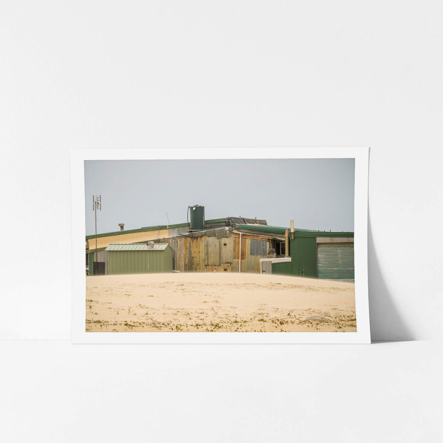 Patchwork at Tin City, green and rust-brown corrugated iron panels sit side by side across a long, low structure.