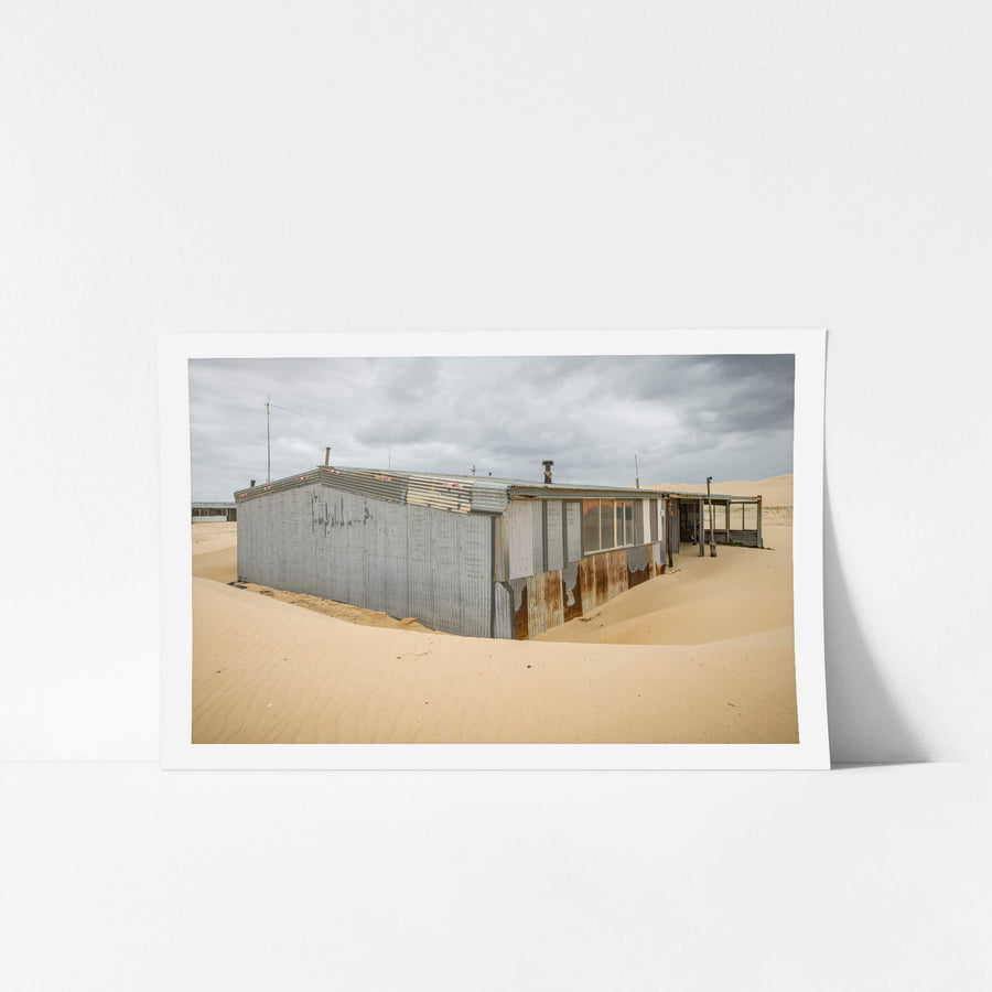 Recess at Tin City, sand banks hard against corrugated iron walls, rising halfway up the structure.