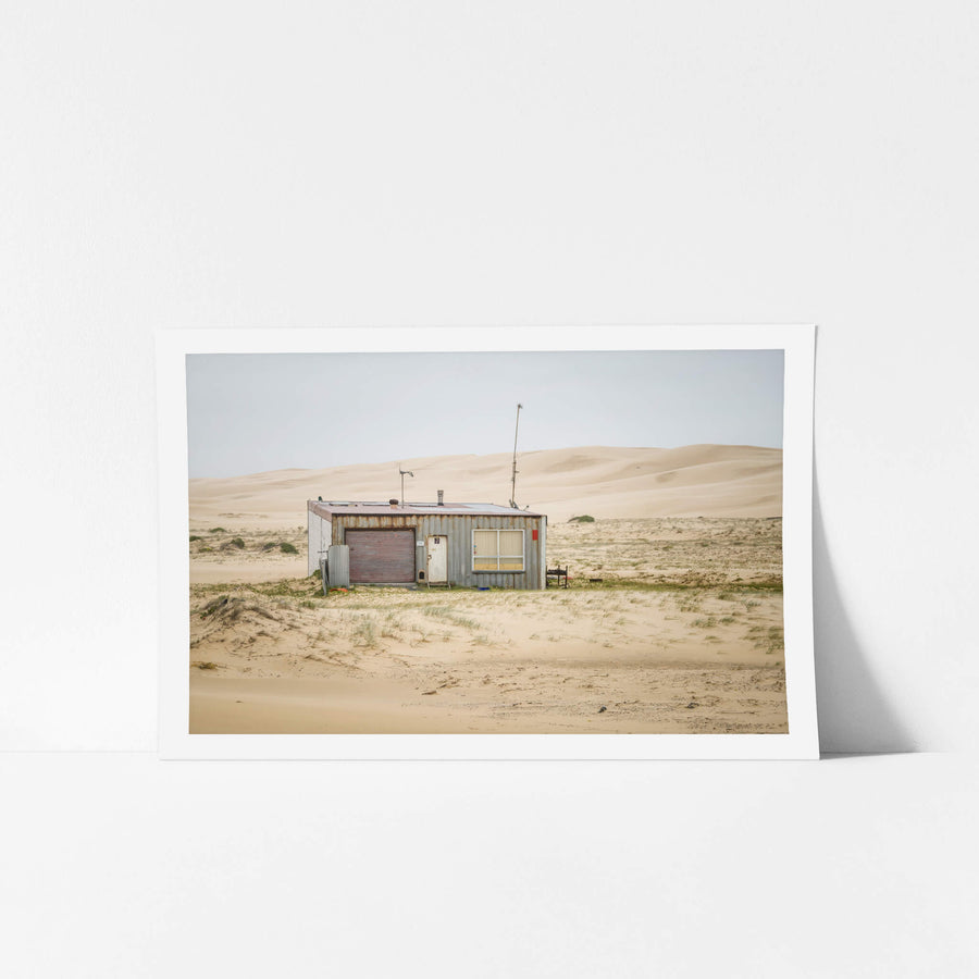 Seven Seven South West at Tin City, shack number seven sits alone against a wall of sand dunes that rises behind it like.