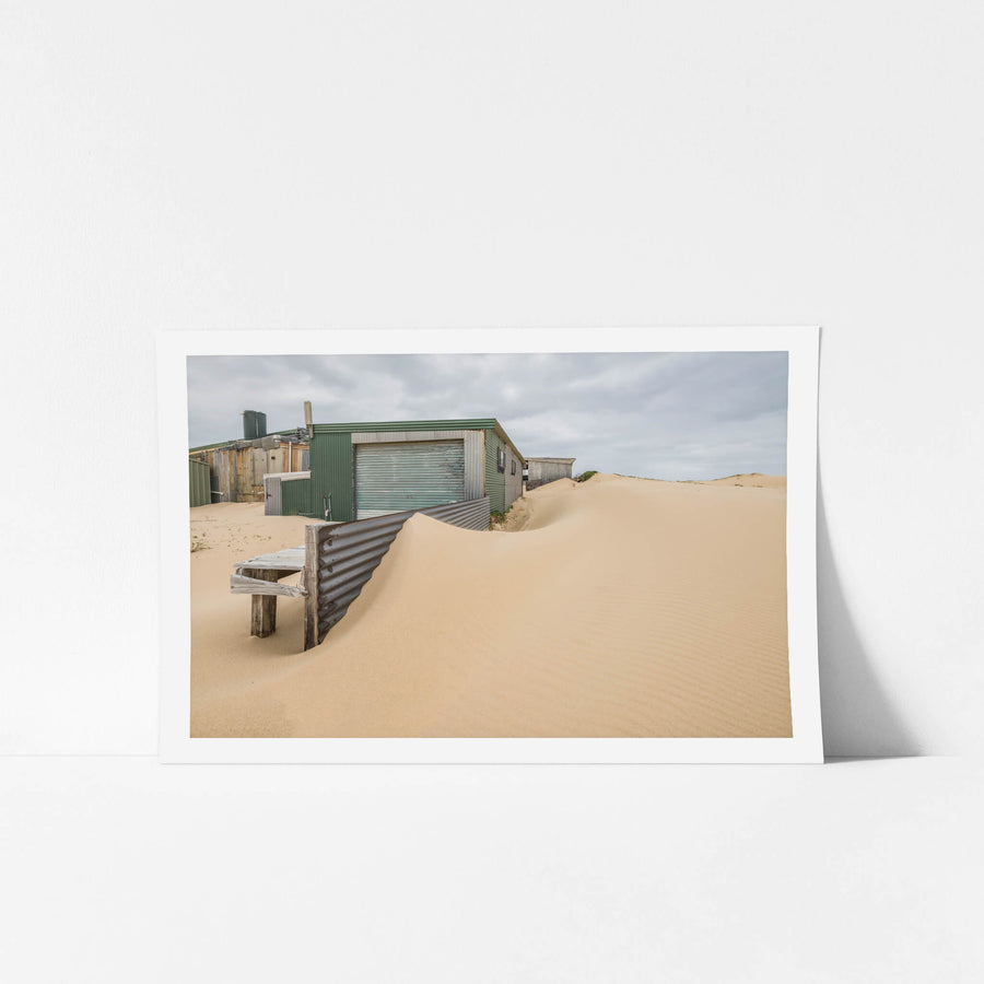 The Outskirts at Tin City, sand dunes press against corrugated iron sheds on the outer edge of Tin City.