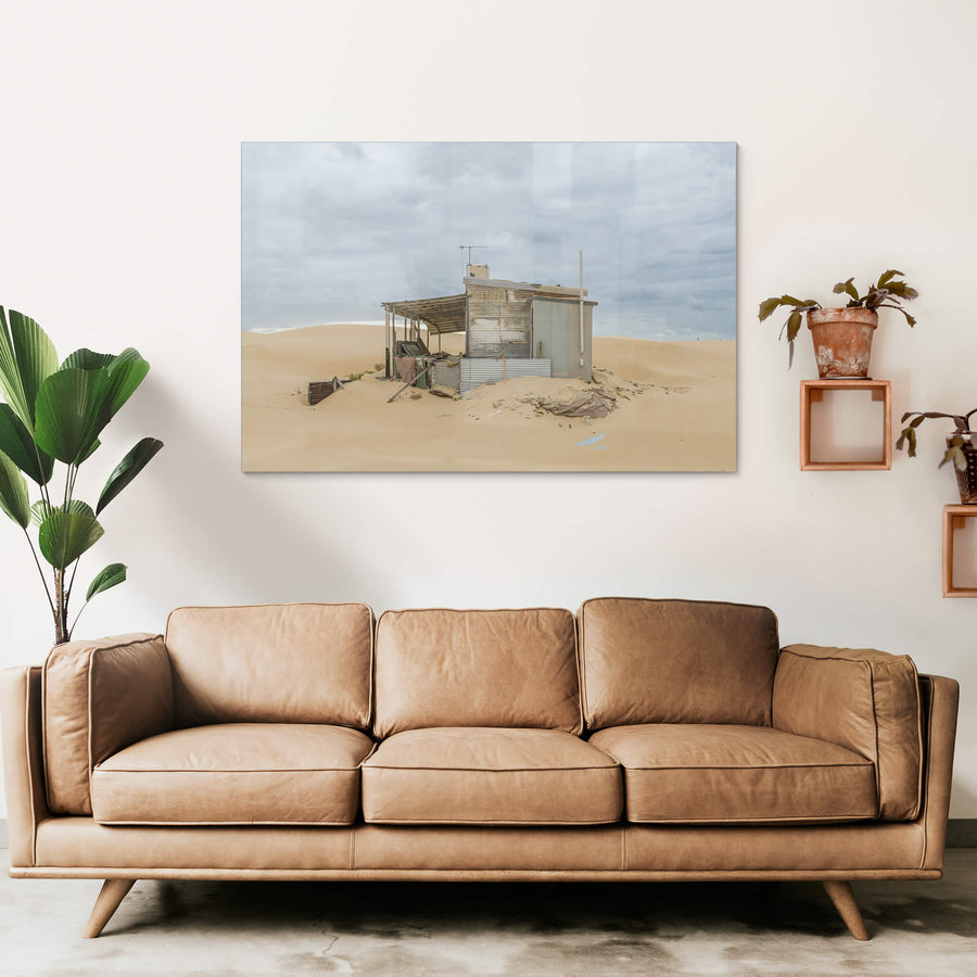 The Porch at Tin City, a corrugated iron shack sits half-swallowed by sand.