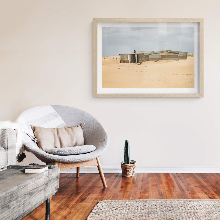 The Workshop at Tin City, a low corrugated iron structure sits half-swallowed by sand dunes at Tin City.