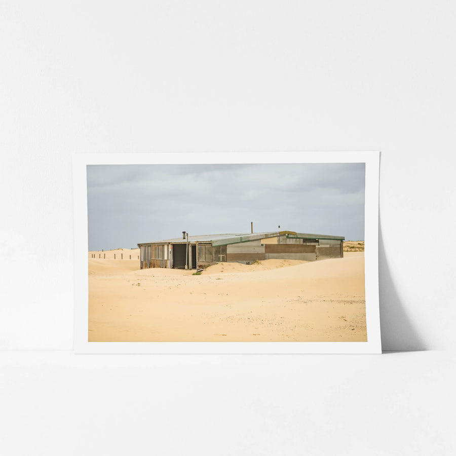The Workshop at Tin City, a low corrugated iron structure sits half-swallowed by sand dunes at Tin City.