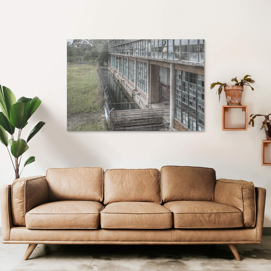 Outlet Canal at Wangi Power Station, brown brick and steel-framed windows rise two storeys above, nearly every pane.