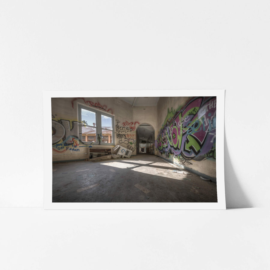 Colour Room at Waterfall Sanatorium, sunlight cuts through a pair of tall windows and falls across a bare concrete floor.