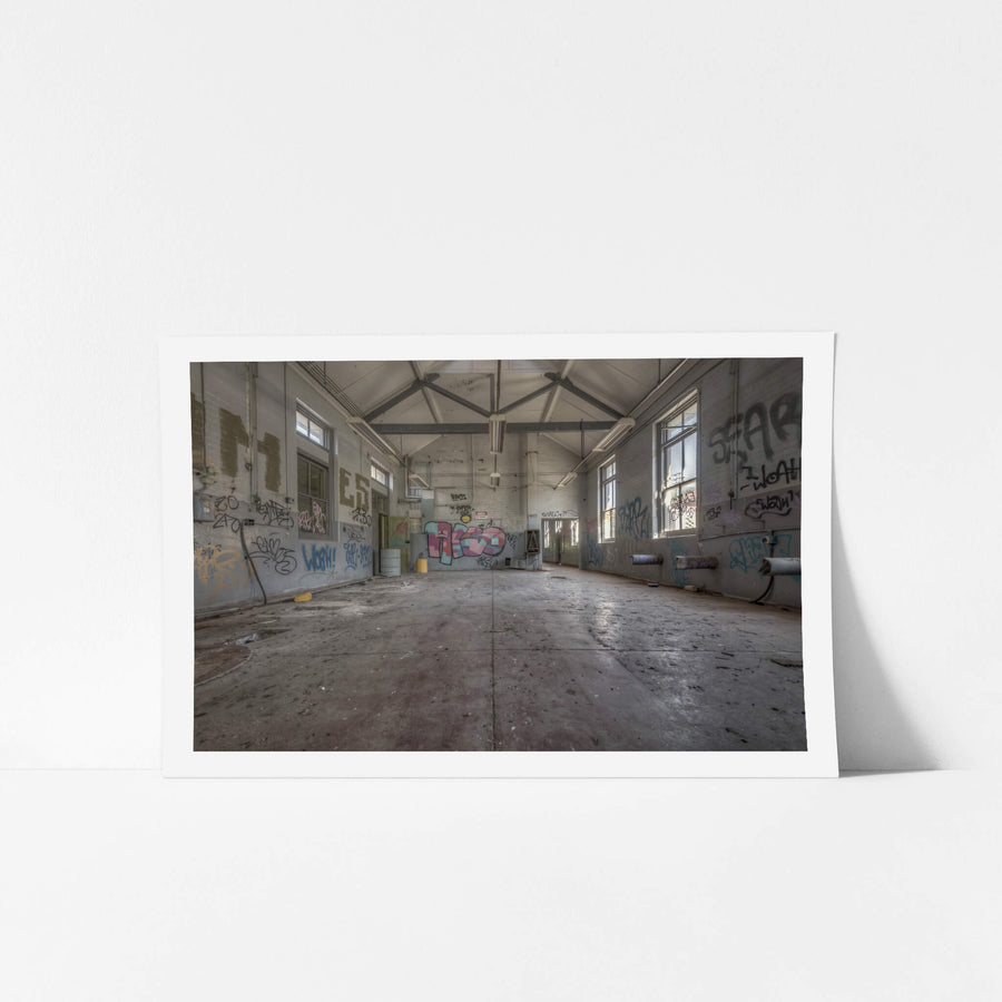 Empty Arches at Waterfall Sanatorium, steel trusses span the pitched ceiling of a long rectangular hall.