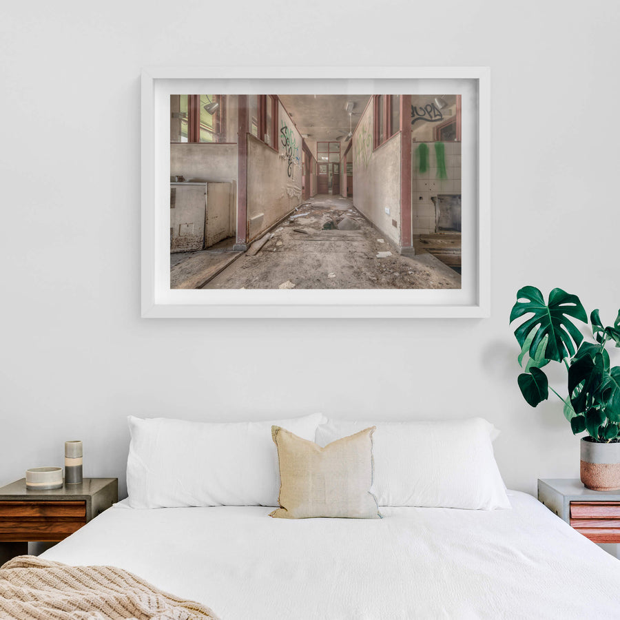 Fallen Through at Waterfall Sanatorium, a corridor runs between partitioned rooms, their maroon-trimmed frames holding.