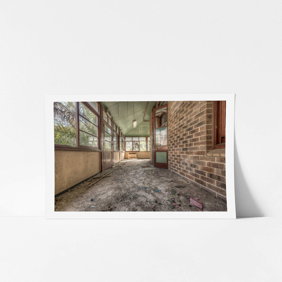Rainforest Escape at Waterfall Sanatorium, a covered verandah runs along the brick facade of a ward building.