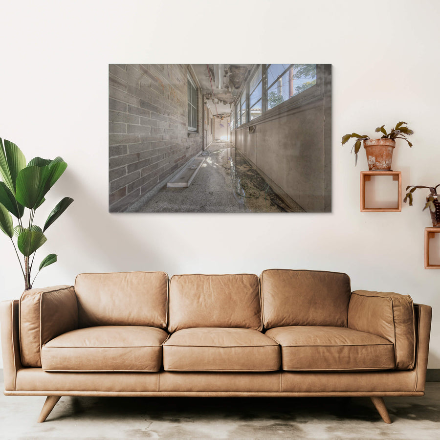 Side Hall at Waterfall Sanatorium, a narrow enclosed corridor runs between a brick wall and a bank of steel-framed windows.