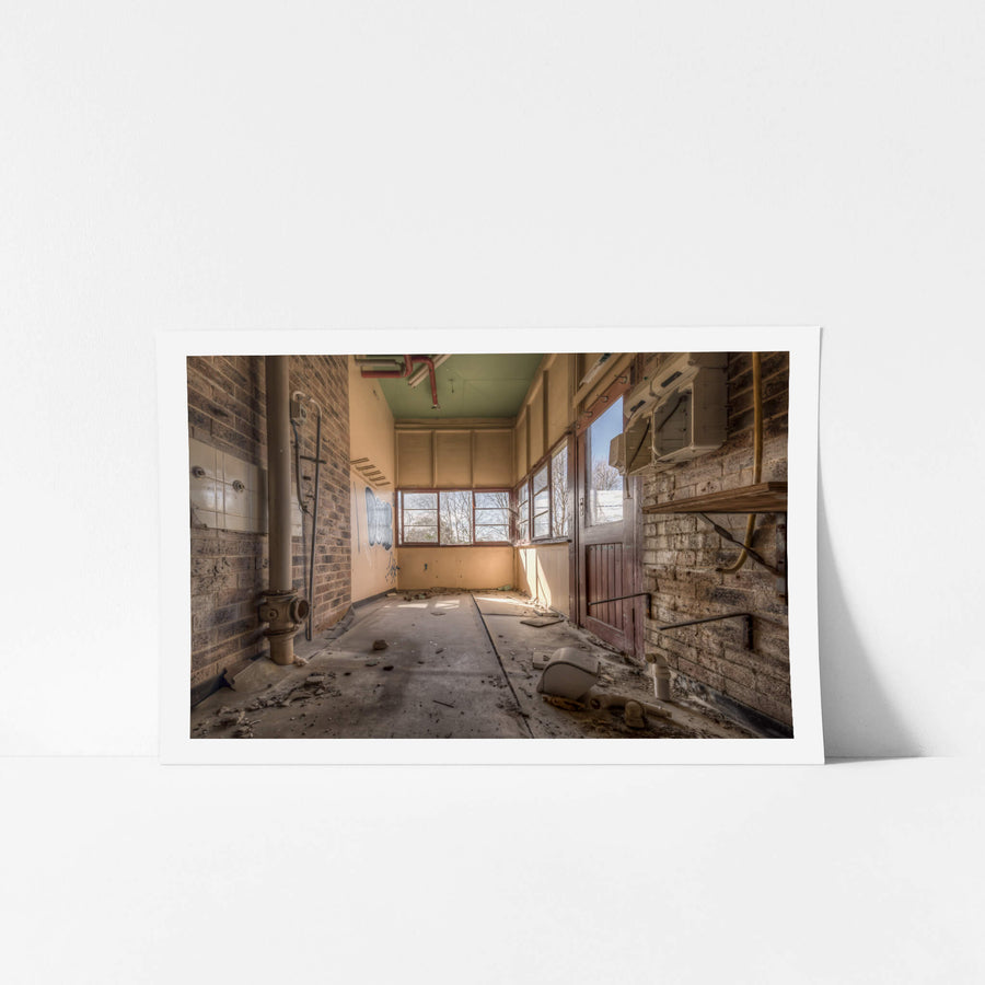 Washroom at Waterfall Sanatorium, a narrow brick corridor opens toward a bank of timber-framed windows.