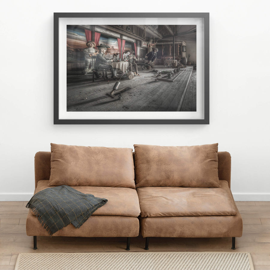 Stageplay at Western Village, animatronic cowboys sit around a checkered tablecloth inside a timber saloon set.
