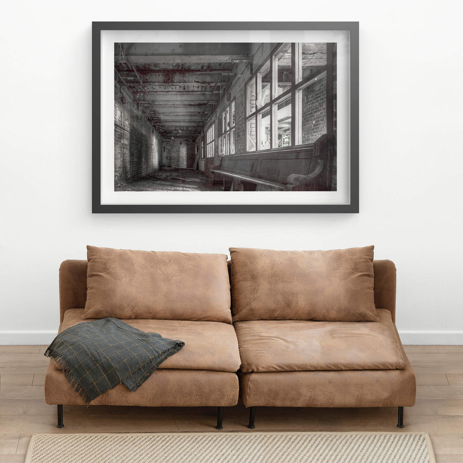 Lunch Room at White Bay Power Station, a timber church pew sits against a wall of broken windows in a narrow brick corridor.