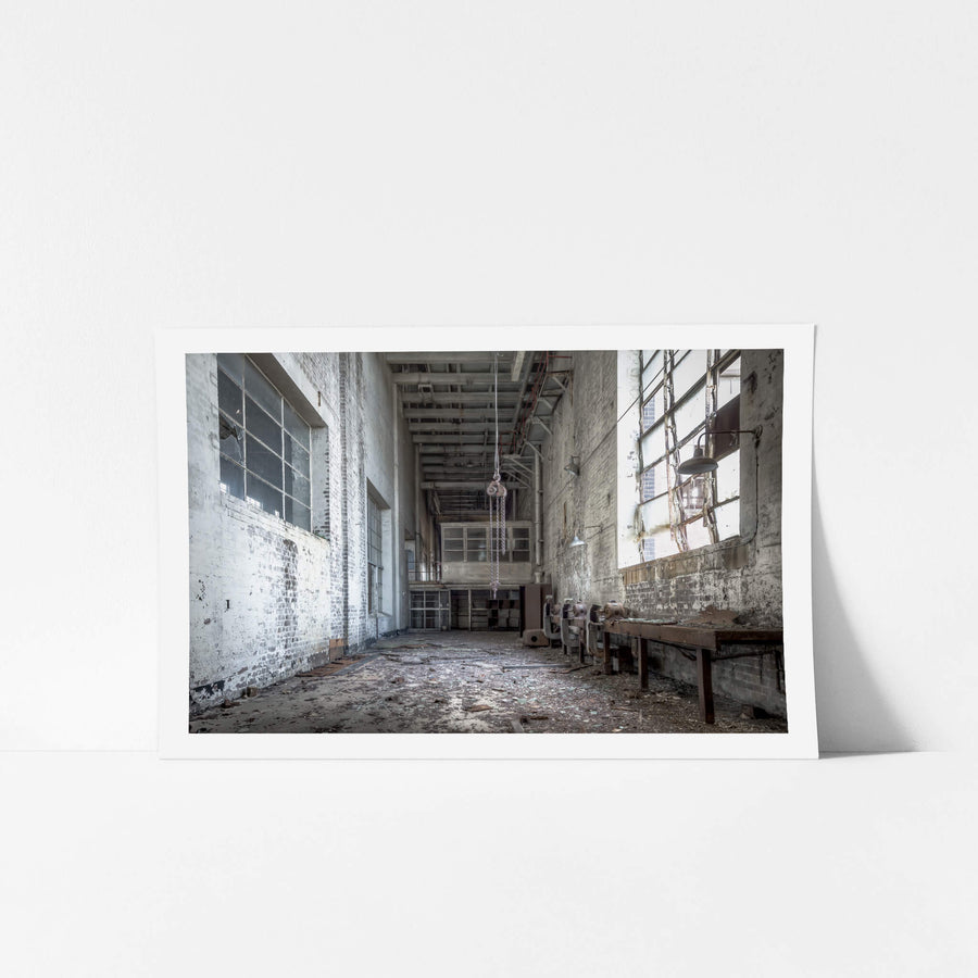 Workshop at White Bay Power Station, a chain block hangs from the ceiling on heavy links, motionless above a floor thick.